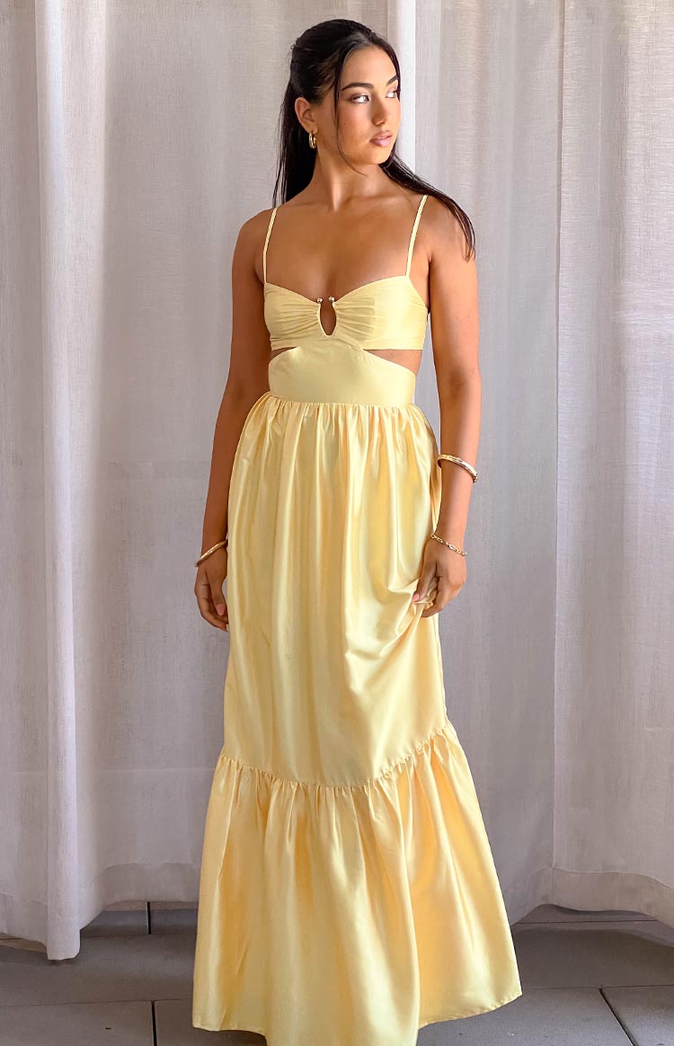 Yellow maxi dress with sweetheart neckline, silver ring detail, side waist cutouts, and ruffled tiered hem