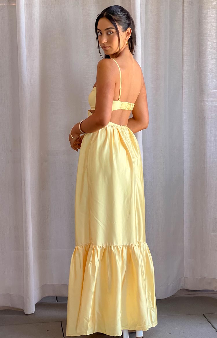 Back view of a yellow maxi dress with thin spaghetti straps, back band, side waist cutouts, and a tiered ruffled hem