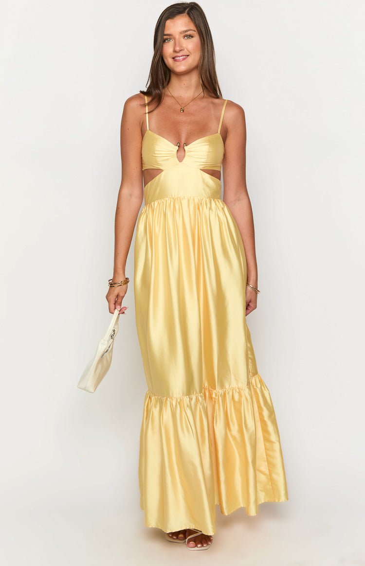 Yellow satin maxi dress with a sweetheart neckline, waist cutouts, and a ruffled tiered hem