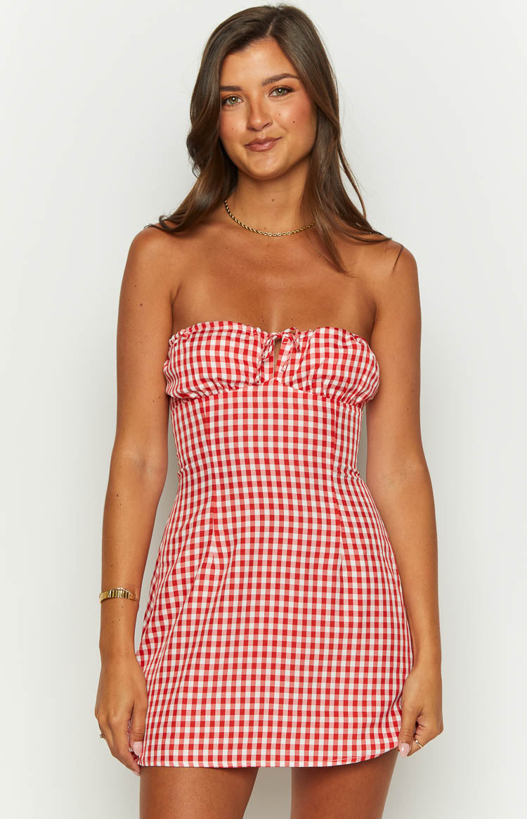 Front view of a red and white gingham strapless mini dress with a ruched bust and tie-front detail