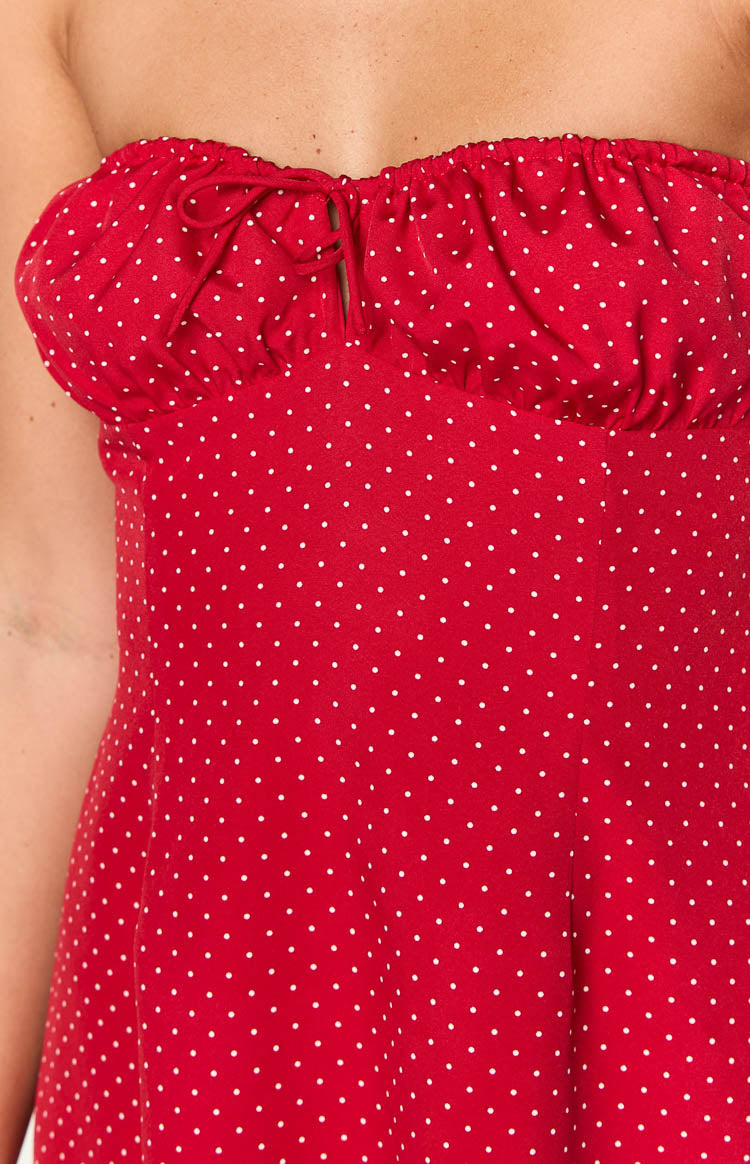 Close-up of the red polka dot mini dress showing the gathered strapless bust with a central tie-front detail