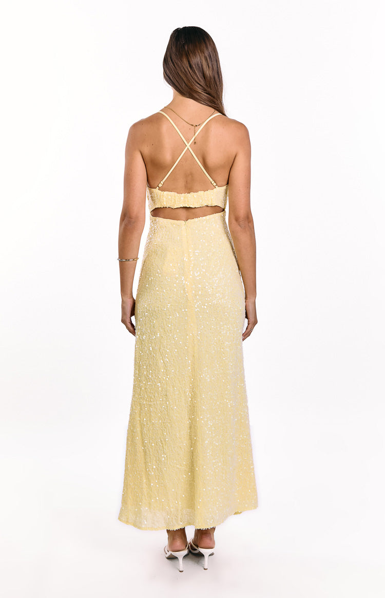 Rear view of a yellow sequin maxi dress with criss-cross back straps and a cut-out waist