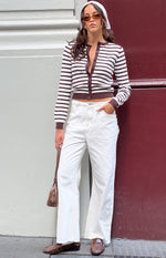 Front view of white high-waisted wide-leg denim jeans with visible light brown stitching and a frayed raw hem