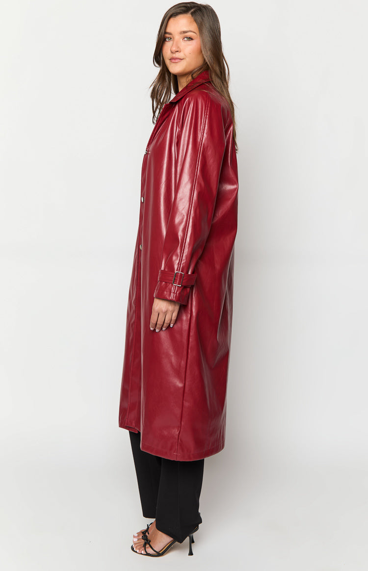 Side view of a long red PU trench coat with buckled cuff straps