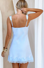 Rear view of a light blue satin mini dress with thin adjustable spaghetti straps and a delicate lace trim hem