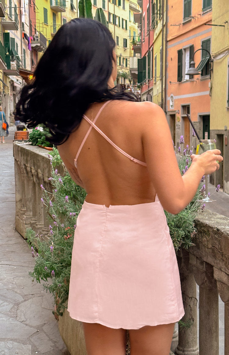 Rear view of the pink mini dress featuring a low open back and thin adjustable criss-cross straps