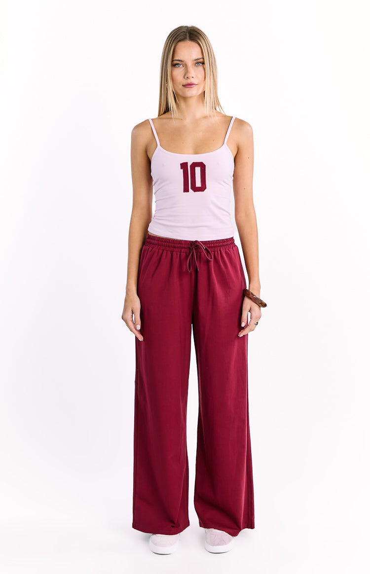 Burgundy wide leg pants with an elasticated drawstring waist and relaxed fit