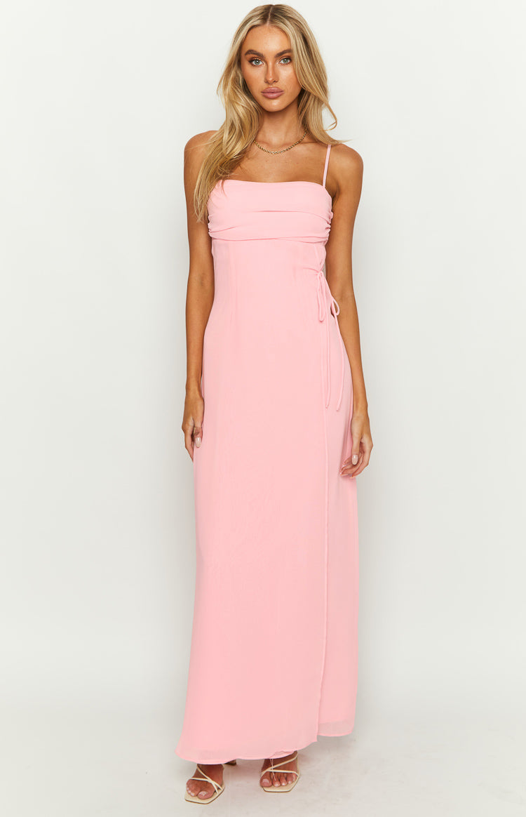 Front view of a pink maxi dress with a straight neckline, ruched bust, thin spaghetti straps, and side tie detail
