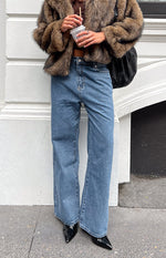 Full length view of mid wash wide leg jeans with a relaxed fit and visible front pockets
