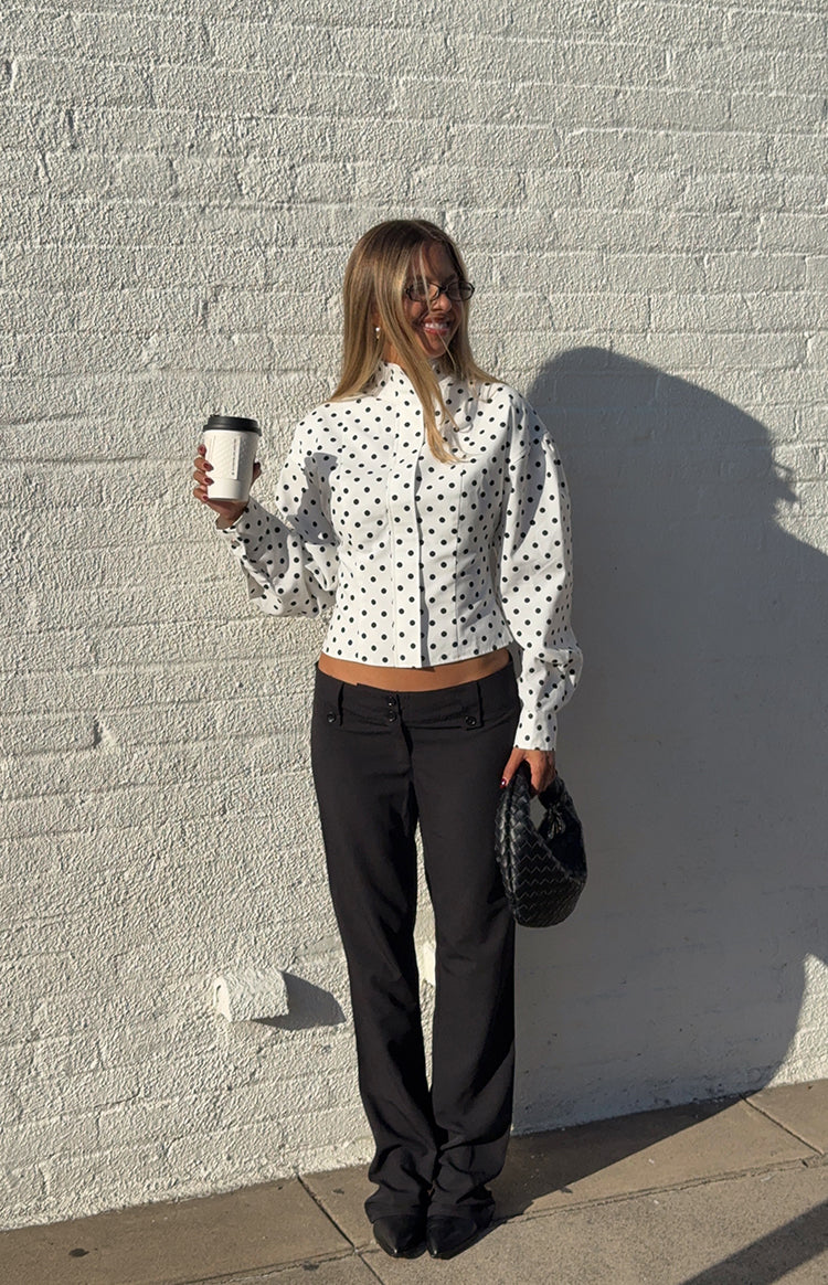 White polka dot jacket with a high neck, long voluminous sleeves, and a cropped button-front hem