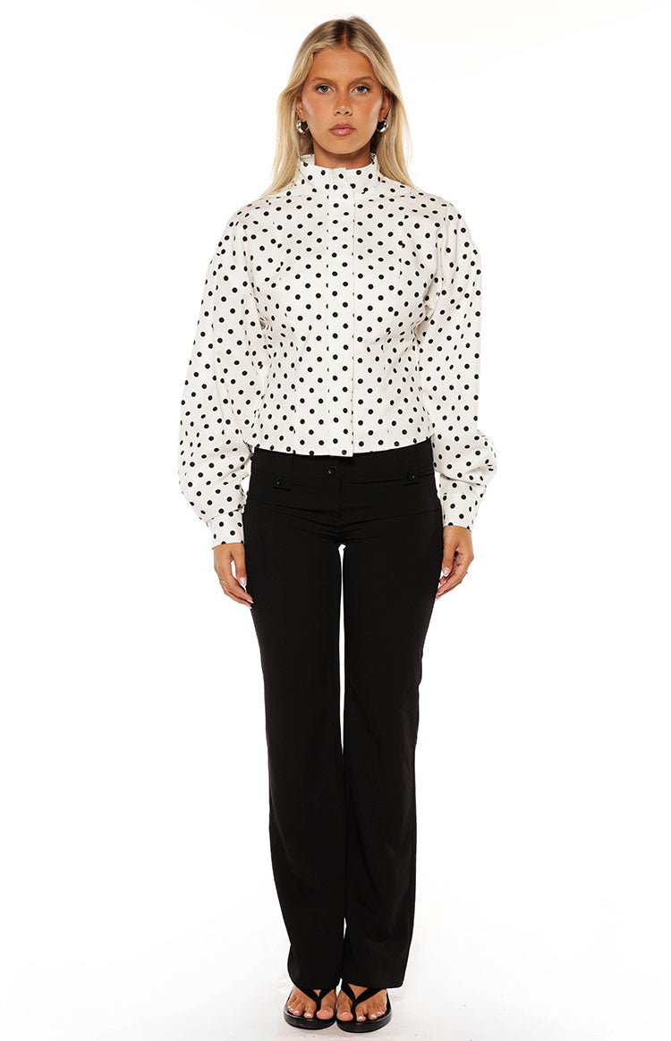 Front view of a white polka dot jacket with a high neck and voluminous long puff sleeves
