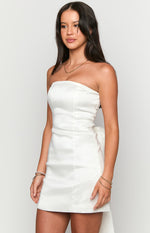 Side view of a white strapless mini dress, highlighting the structured bodice and the large bow detail