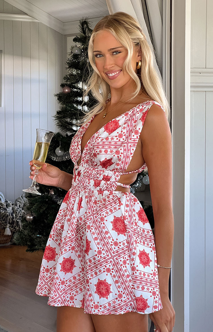 Red tile print mini dress with a deep V-neckline, ruched waist, and side cutouts with tie details
