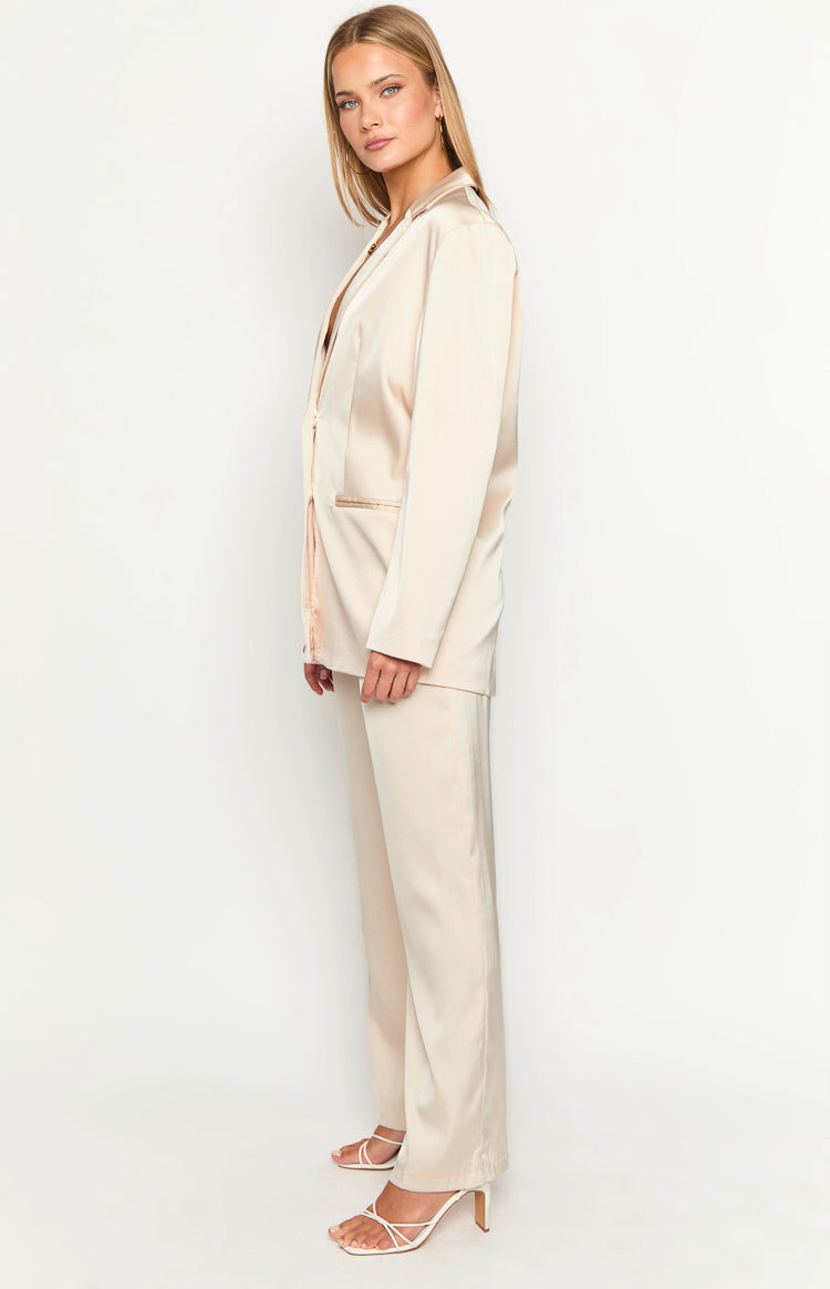 Side view of a cream satin blazer, showing the open front, notched lapels, and a flap pocket