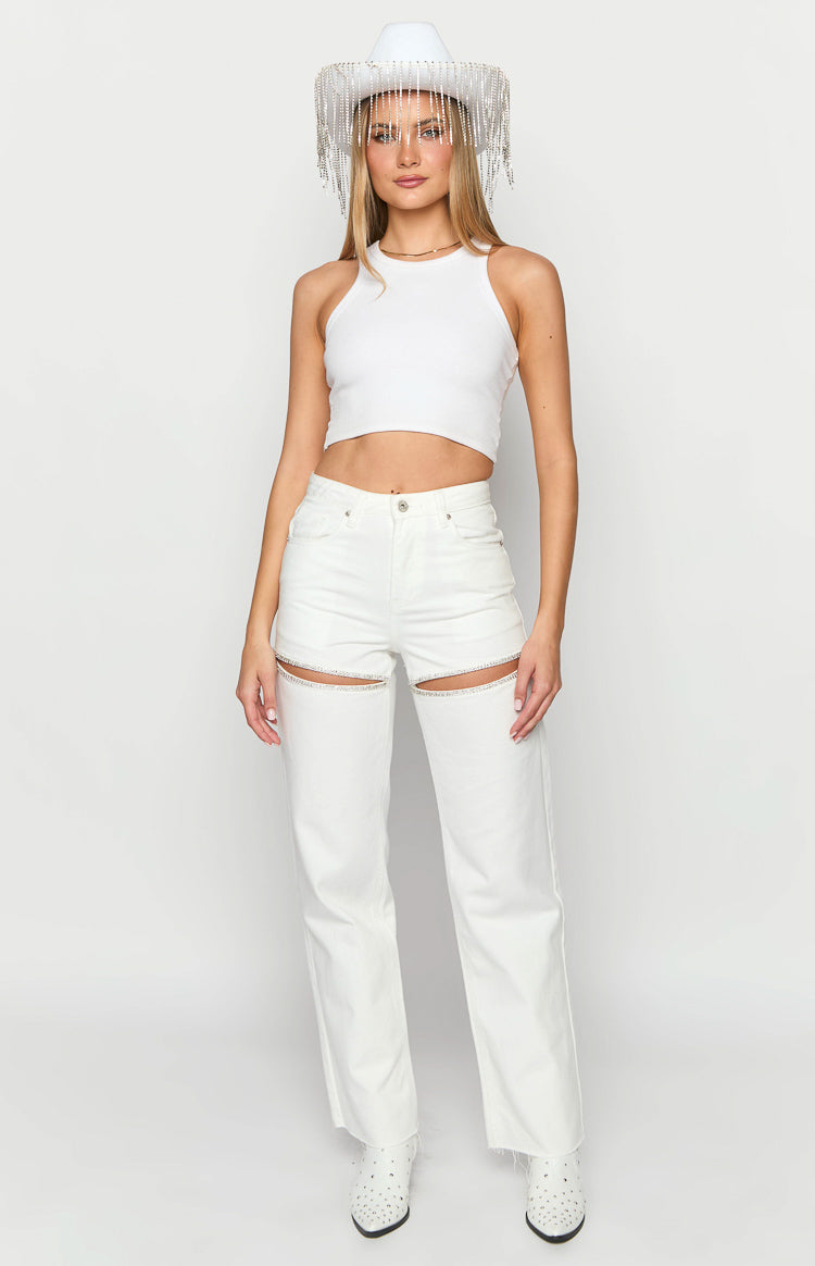 Front view of white wide-leg denim jeans with diamante trim cutouts on the thighs and frayed hems