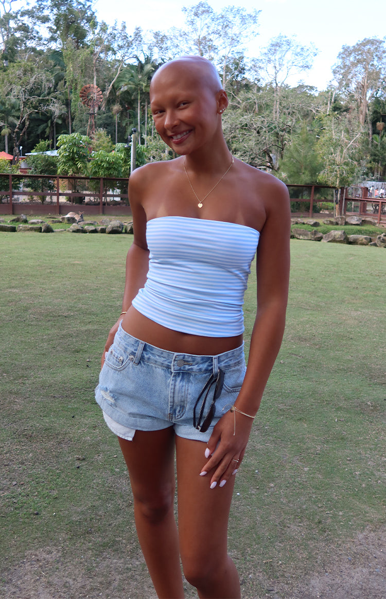Light wash denim shorts with distressed rips, frayed hems, and a relaxed fit