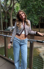 Chocolate and white striped round neck cardigan worn open, showing its cropped length and long sleeves