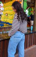 Rear view of light wash low rise denim jeans with a star outline embroidered on the back pocket