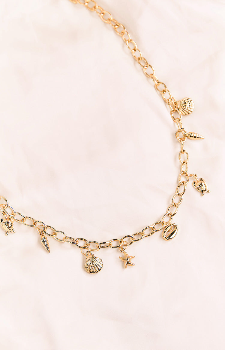Detail shot of a gold chain belt featuring shell starfish and turtle charms