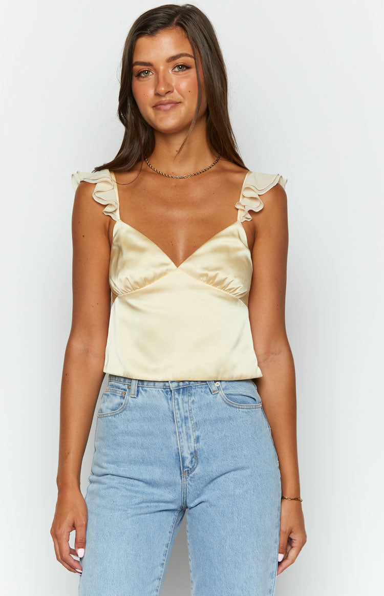 Front view of a golden yellow satin V-neck crop top with delicate ruffled cap sleeves