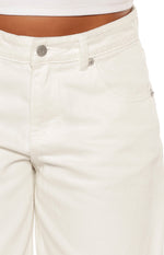Close-up of the white denim shorts showing the silver button closure, belt loops, and front pocket details