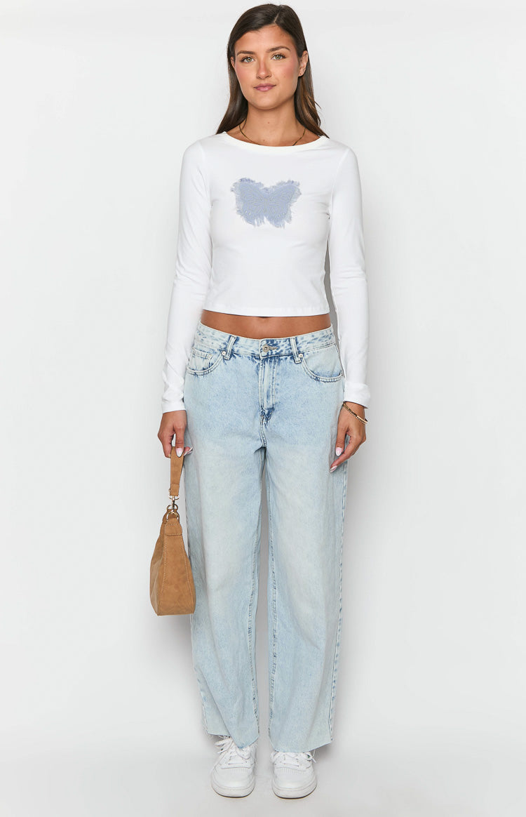 White long sleeve crop top with a light blue butterfly graphic on the chest and a wide scoop neck