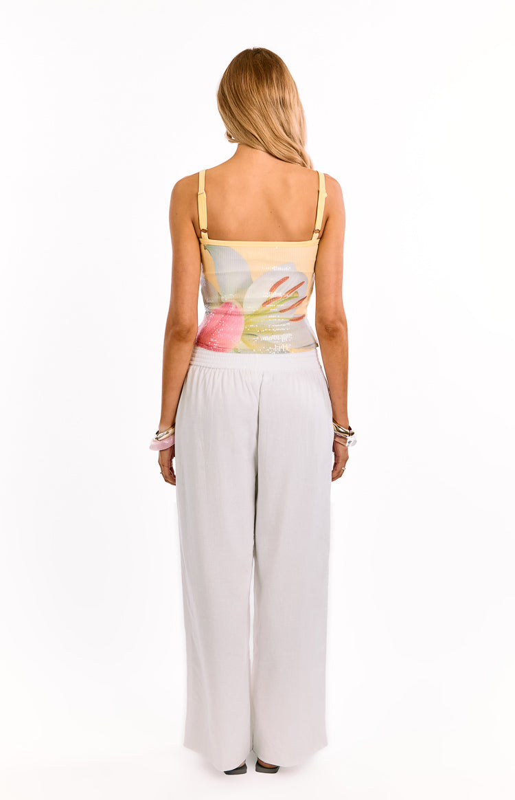 Rear view of a yellow floral sequin tank top with thin adjustable spaghetti straps and a straight back neckline