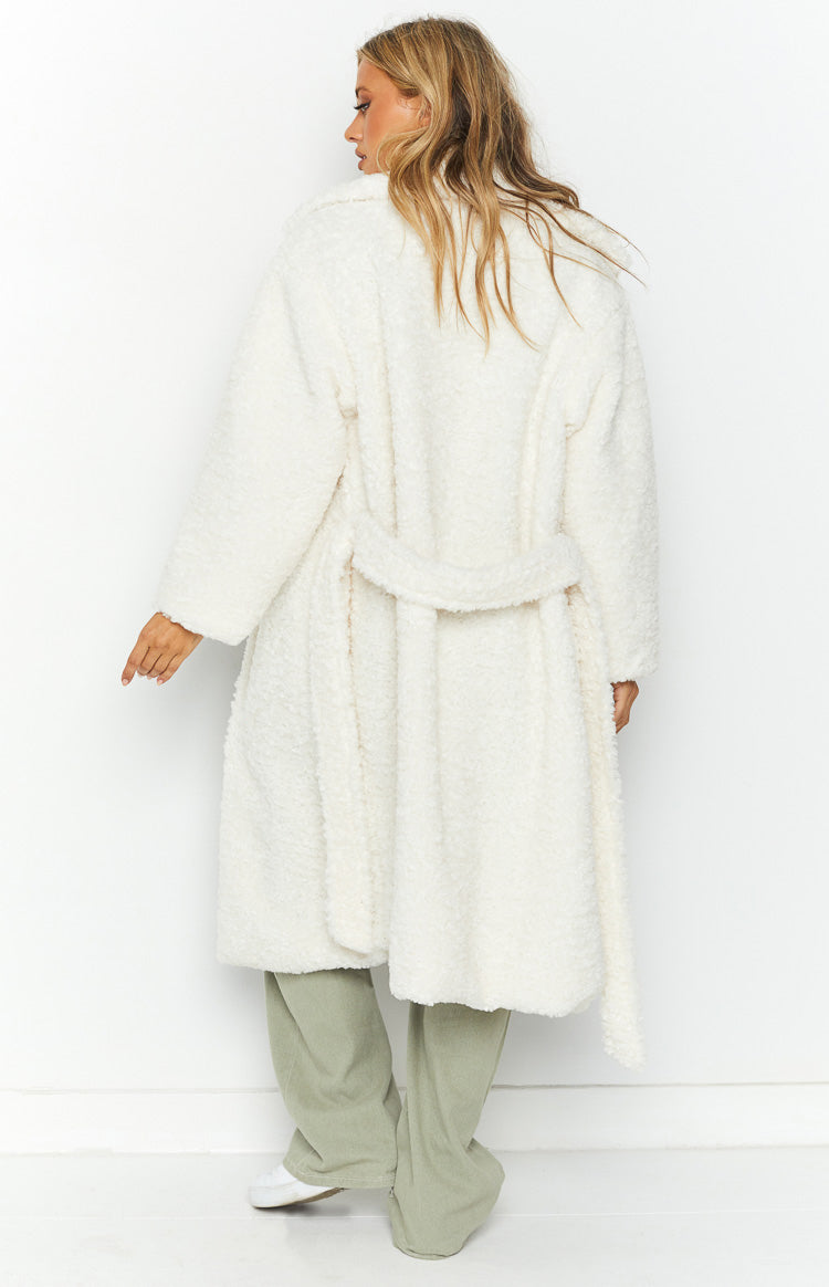 Rear view of a white midi length teddy coat with long sleeves and a belted waist