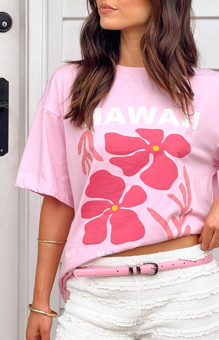 Pink oversized tee with a large graphic print of pink hibiscus flowers and "HAWAII" text