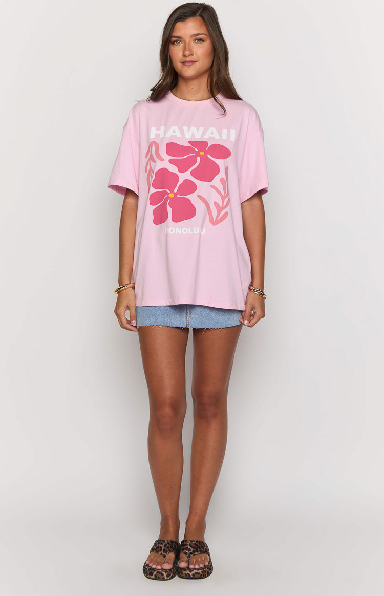 Front view of an oversized light pink tee with a white "HAWAII" graphic and two large pink hibiscus flowers