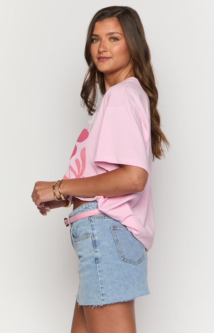 Side view of a pink oversized tee with short sleeves and a partial coral abstract graphic