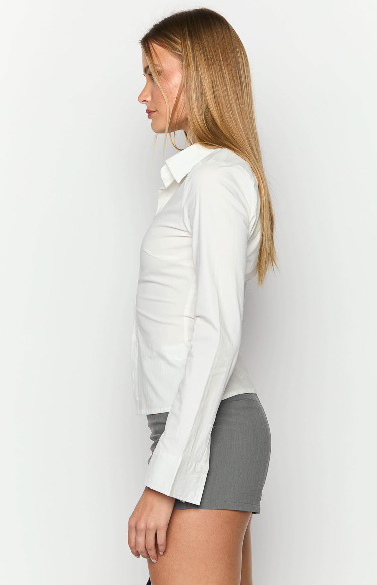 Side view of a white fitted long sleeve shirt showing the tailored silhouette and buttoned cuffs