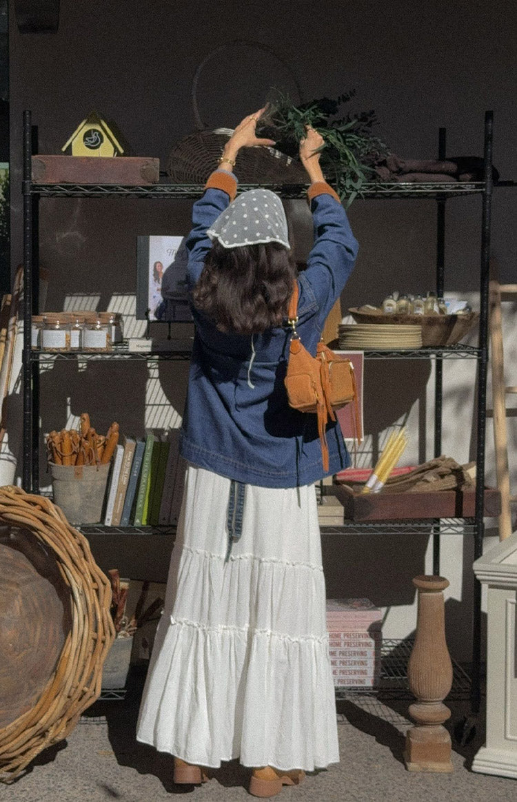 Rear view of a mid wash denim oversized jacket with orange cord trim on the cuffs