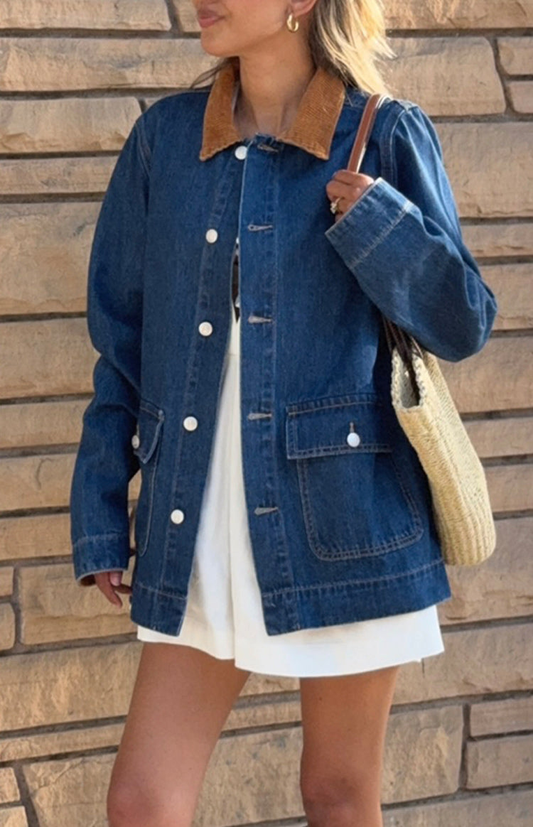 Front view of an open mid wash denim oversized jacket with a brown corduroy collar and white buttons