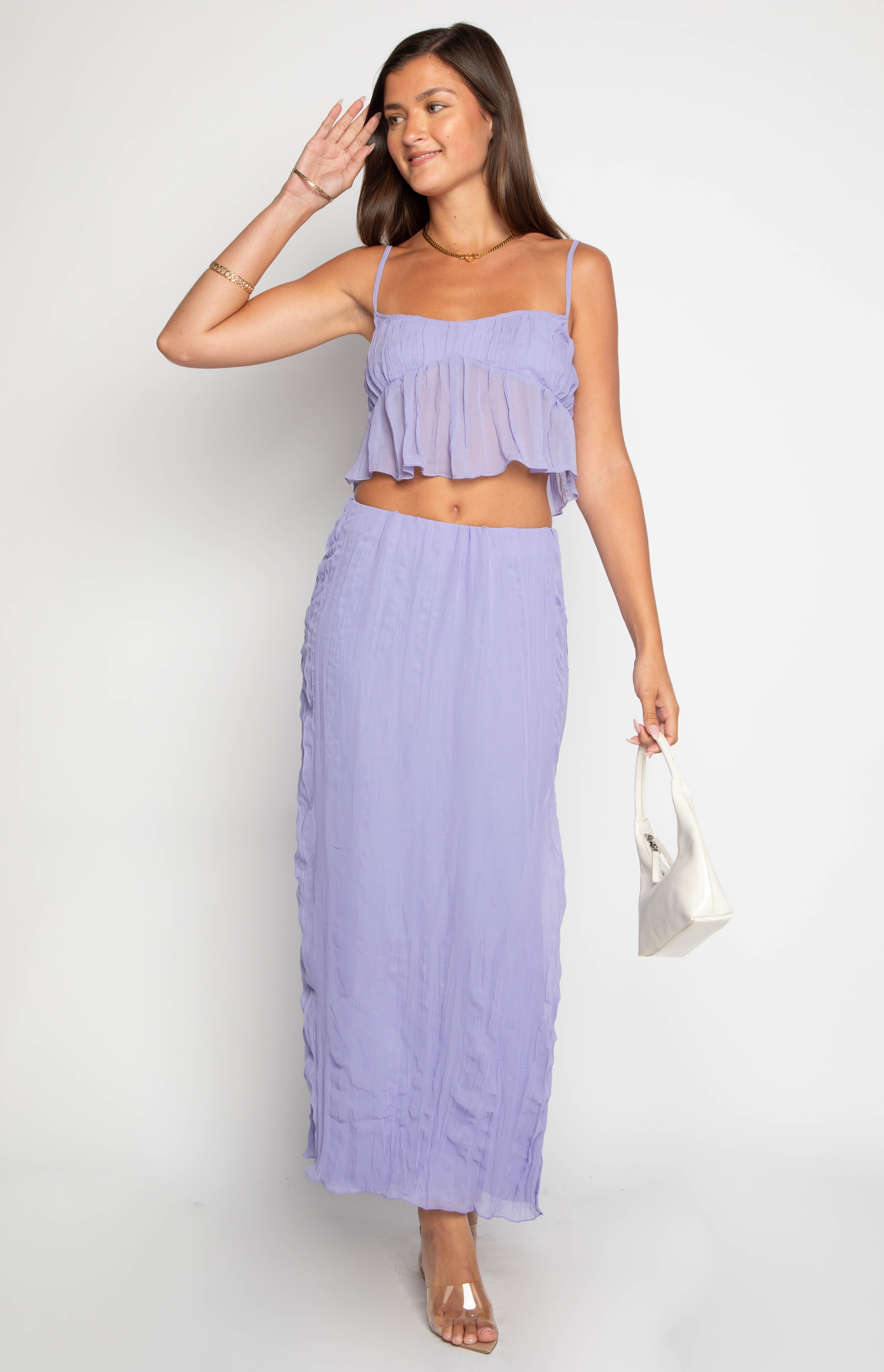Full length view of a sheer purple crinkled maxi skirt with a fitted waist and vertical ruching down the sides