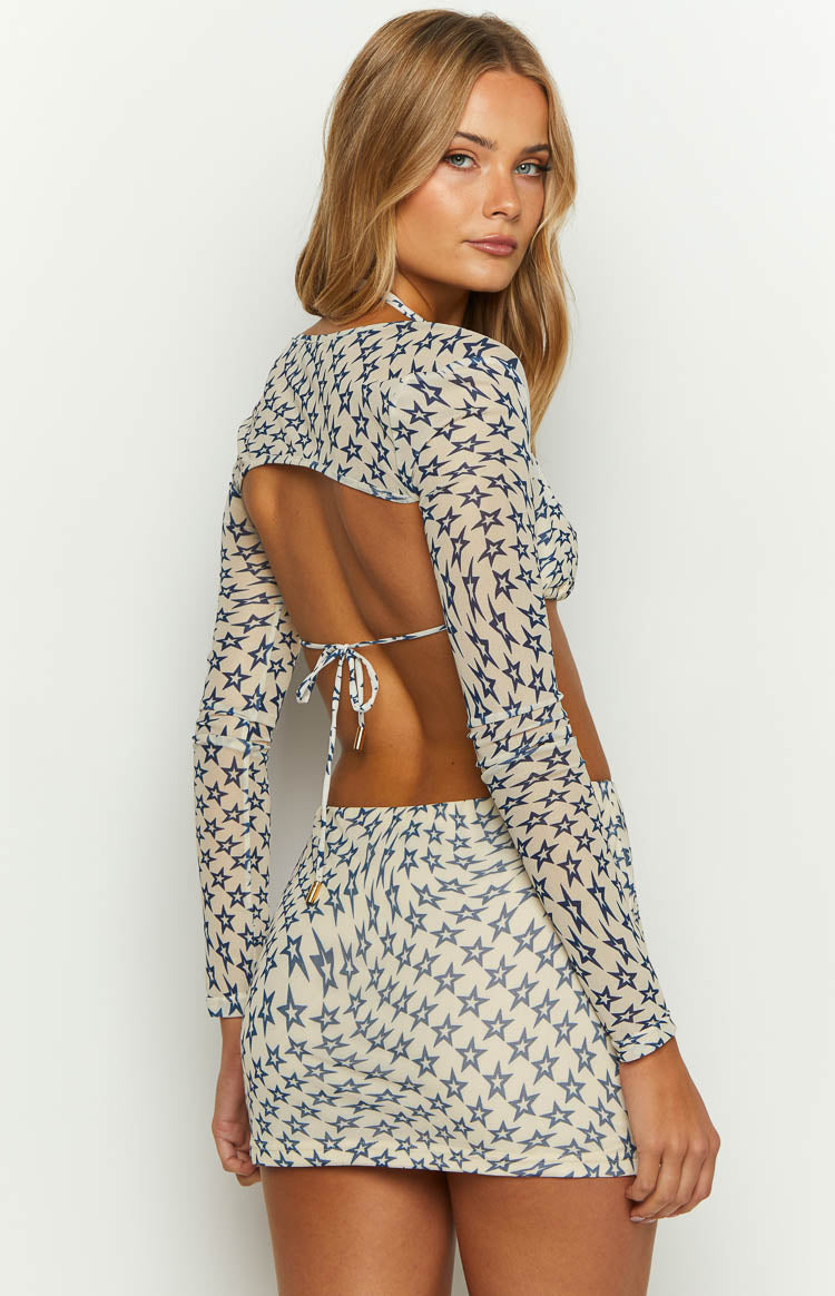 Side view of a fitted cream mini skirt with a blue star print