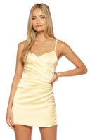 Model wearing a pale yellow strapless slip dress with spaghetti straps and a side slit ideal for a date night