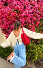 Rear view of a cream chunky knit cardigan with a deep V-back and tie-up detail