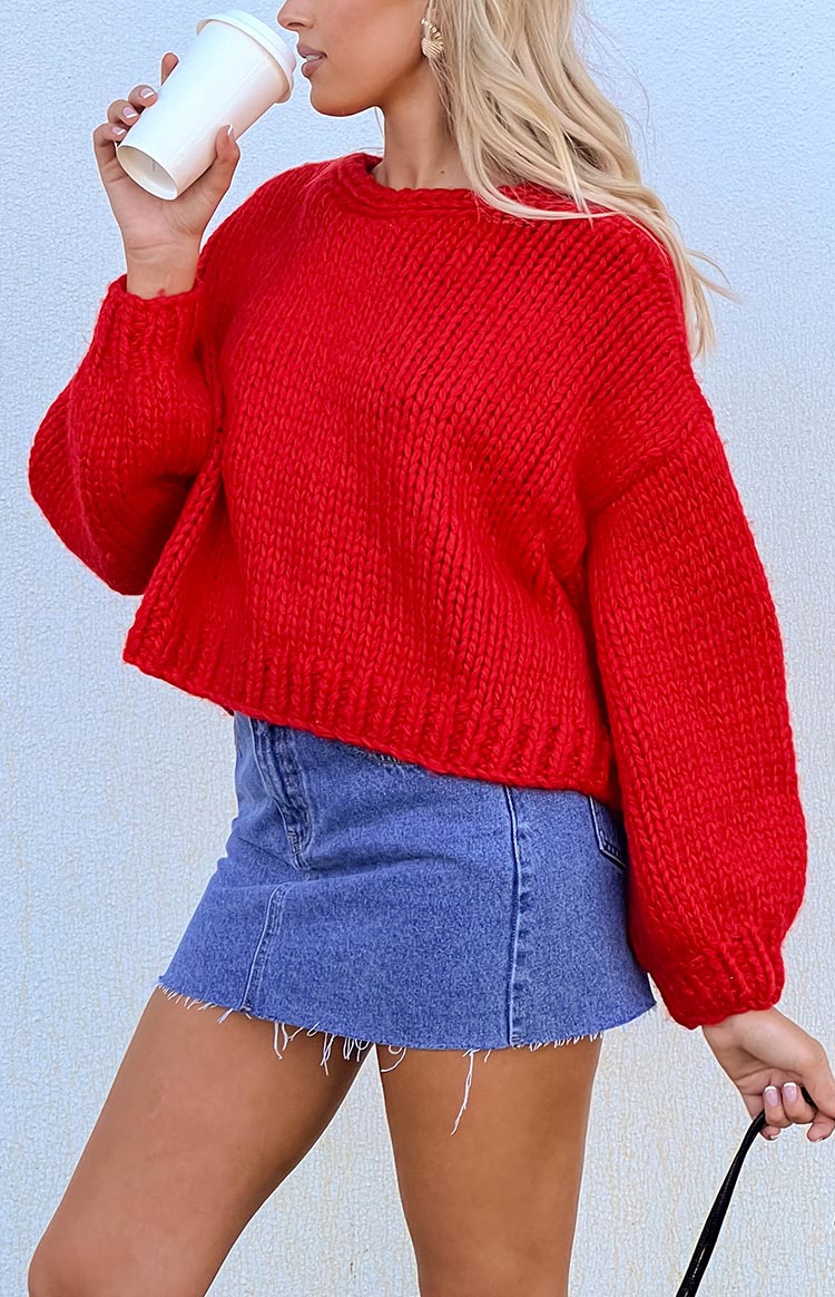Red chunky knit cardigan with a round neckline and long, relaxed fit balloon sleeves