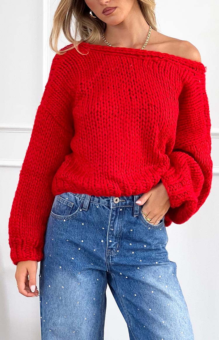 Red chunky knit cardigan with a wide off-the-shoulder neckline and voluminous balloon sleeves with ribbed cuffs