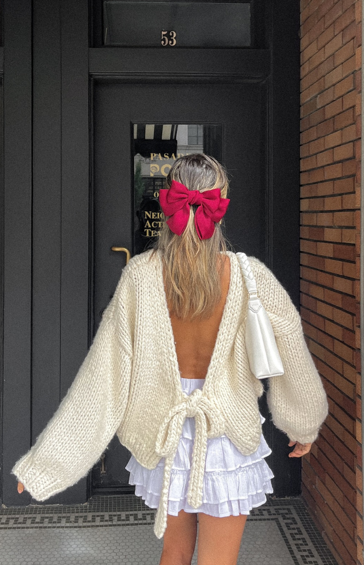 Rear view of a cream chunky knit cardigan with a deep V-back and a tie-up closure at the lower back