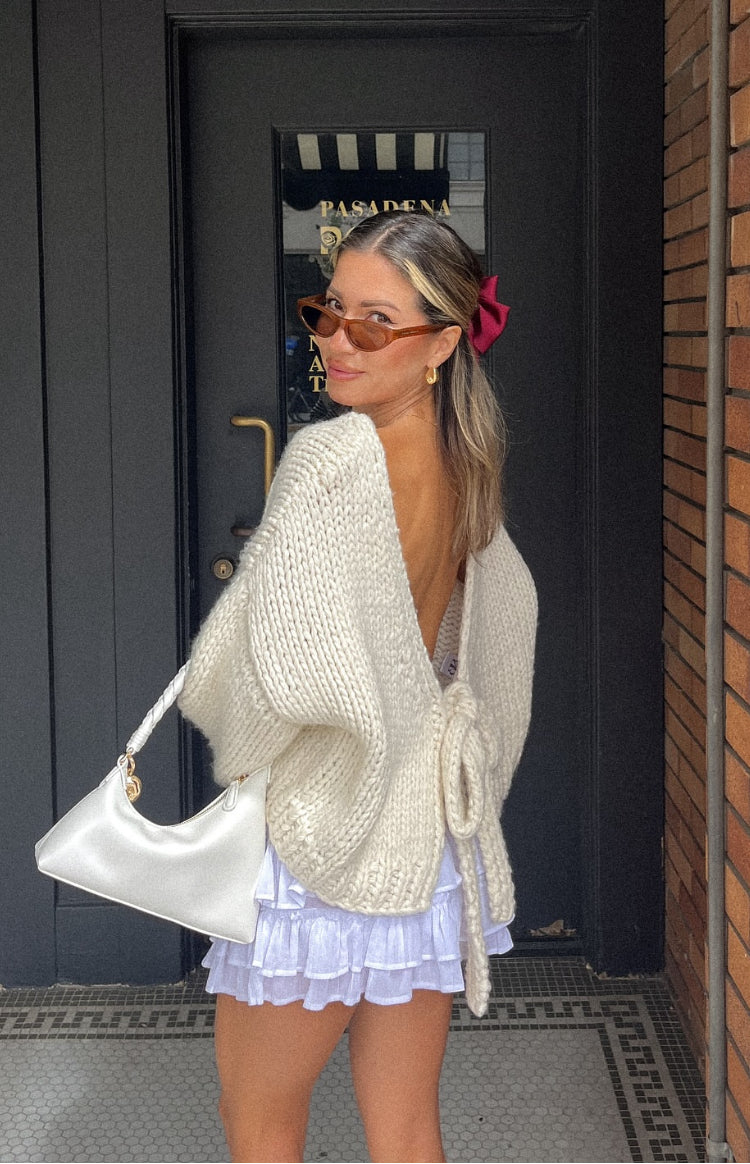 Rear view of a cream chunky knit cardigan with a deep V-back and waist tie detail