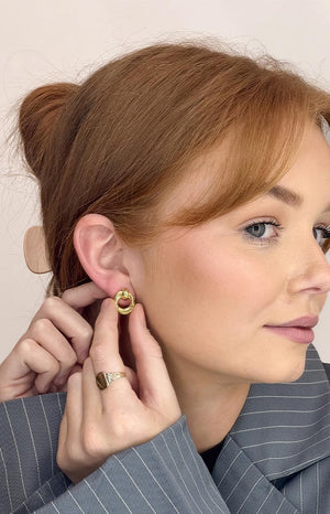 A model wears the chunky gold hoop earring, shown from a slight front angle to highlight its classic shape