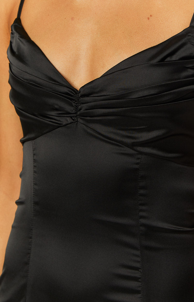 Close-up showing the ruched V-neck bodice and satin fabric of a black mini dress