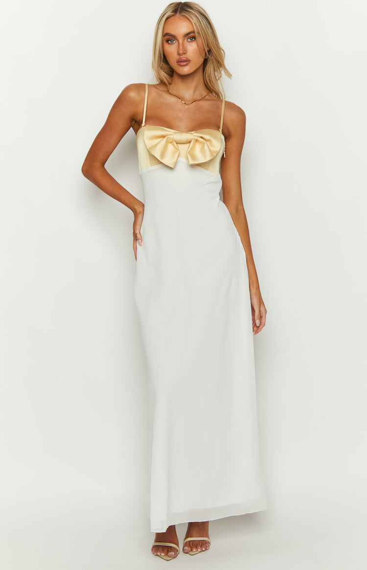 Front view of a honeydew yellow satin bow bodice with thin spaghetti straps and a flowing white maxi skirt
