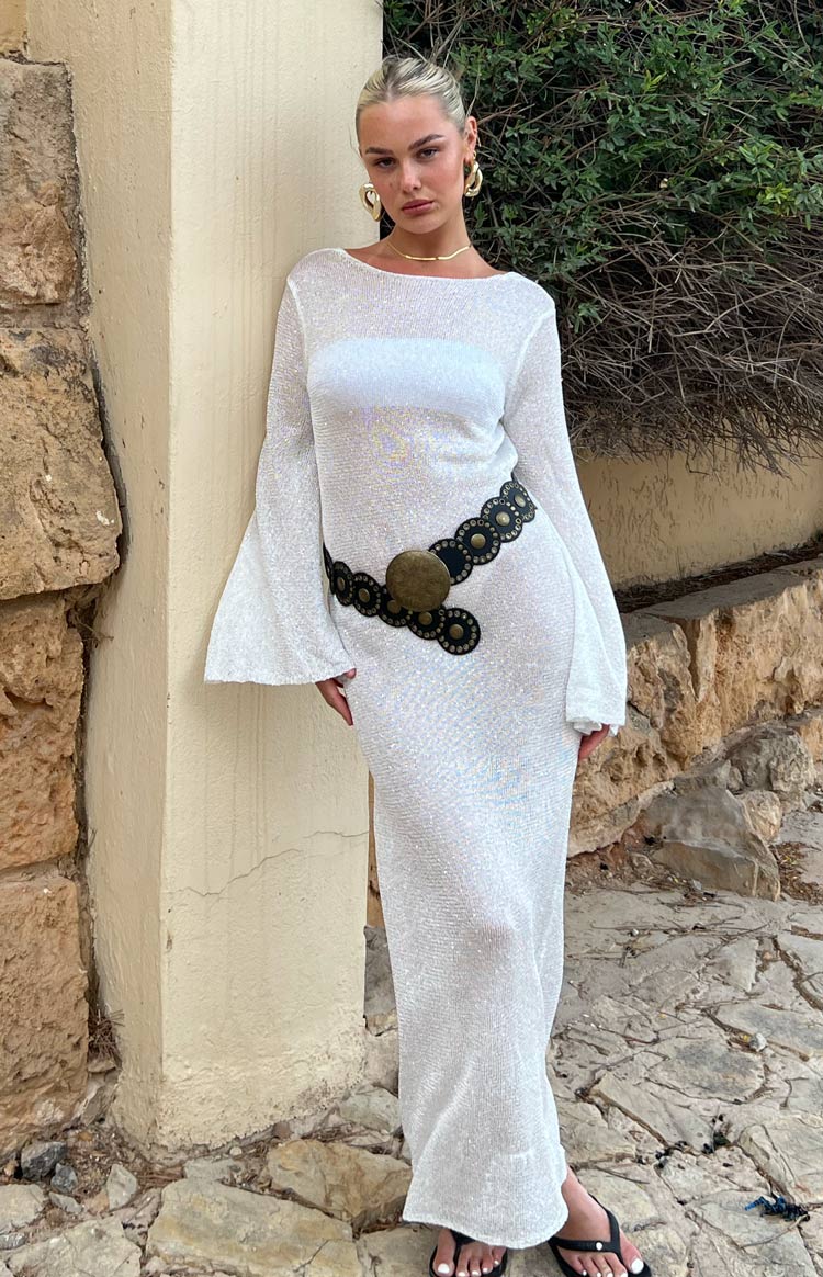 Full-length front view of a fitted sheer white sequin knit maxi dress with boat neck and flared long sleeves