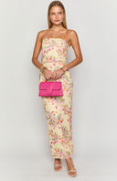 Blonde model wearing a strapless yellow mesh maxi dress with a floral design paired with white heels and gold jewellery
