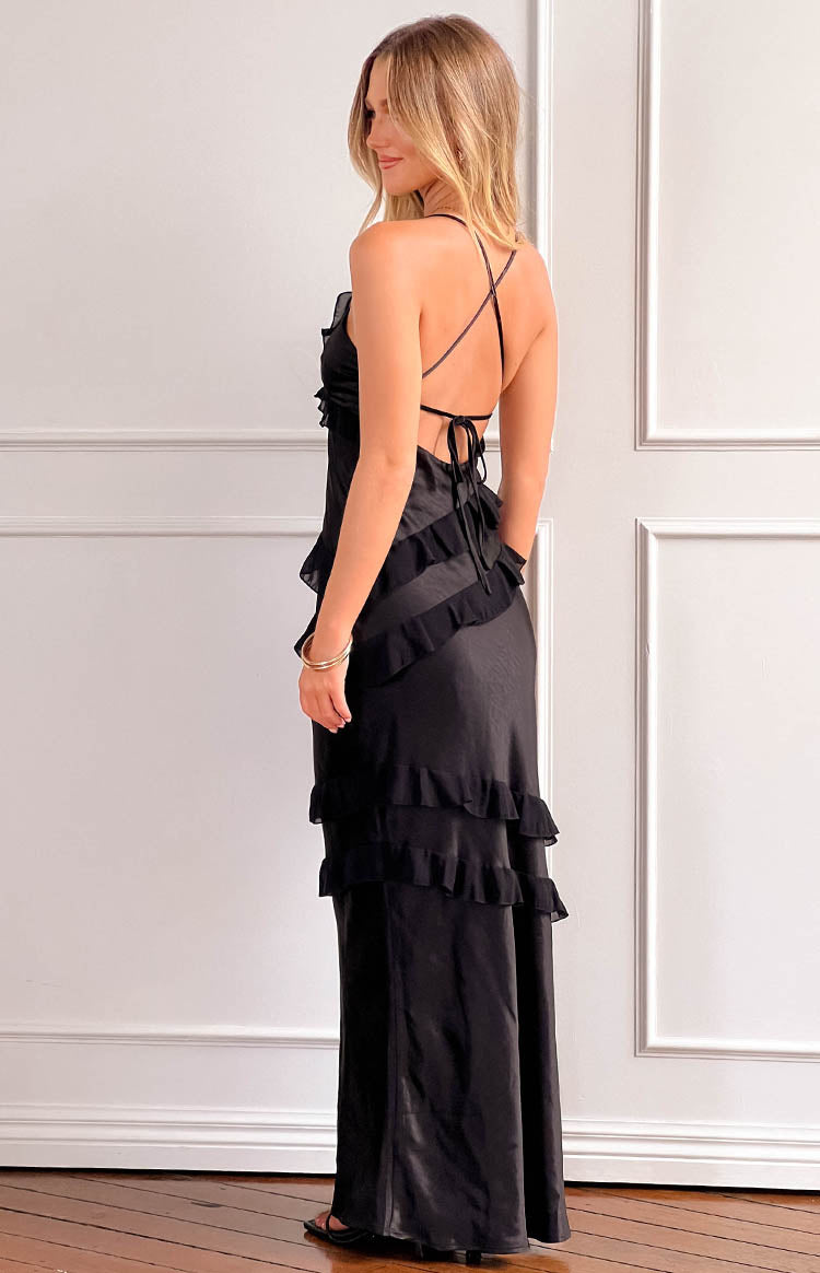 Rear view of a black maxi dress with thin criss-cross back straps, a tie-back, and tiered ruffles