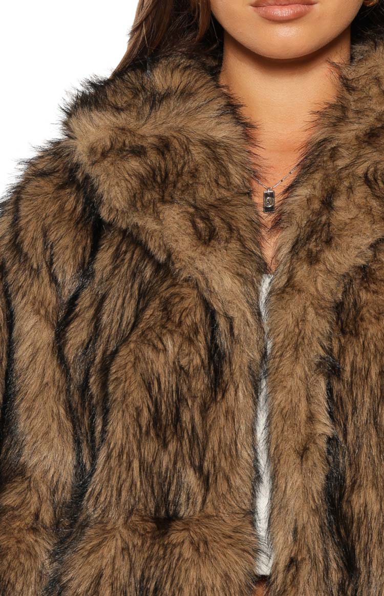 Close-up of the chocolate faux fur jacket showing the shaggy brown and black fur texture and wide lapel