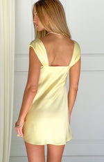 Rear view of a yellow satin mini dress with a low square back and wide gathered shoulder straps